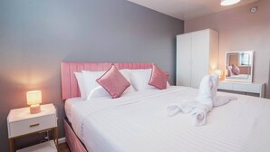 Ein Hotelzimmer mit Bett, Nachttisch, Kleiderschrank und Spiegel.