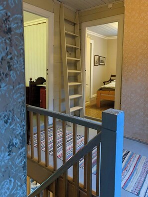 A staircase leading to a bedroom with a bed and a dresser. - Swiss-style farmhouse with fjord views (Bjoa)