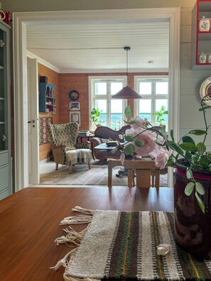 A wooden dining table with a woven placemat and a vase with flowers. - Swiss-style farmhouse with fjord views (Bjoa)