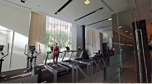Een moderne sportschool met loopbanden, hometrainers en krachttoestellen.