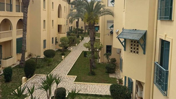 A courtyard with multiple buildings, each with balconies and a central pathway.