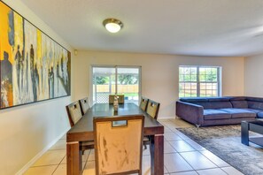 A dining area with a table and chairs, a large painting on the wall, and a sofa in the adjacent living area. - 6 Mi to Dtwn! Centrally Located Sarasota Home (Sarasota)
