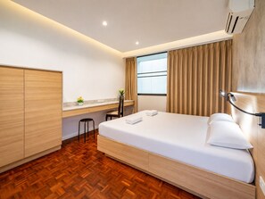 A hotel room with a bed, a desk, a chair, a wardrobe, and a window with curtains. - Beachfront Duplex in Jomtien 3BR with Pool & Gym. Sea view & Night market. 8ppl (Pattaya City)
