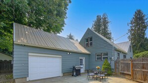 A residential property with a garage, a patio with outdoor furniture, and a wooden fence. - Walk to Dtwn Sandpoint! Family Gem w/ Patio & Yard (Sandpoint)