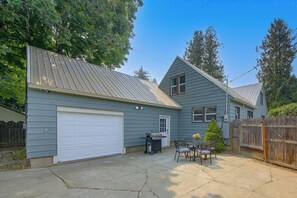 A residential property with a garage, a patio with outdoor furniture, and a wooden fence. - Walk to Dtwn Sandpoint! Family Gem w/ Patio & Yard (Sandpoint)