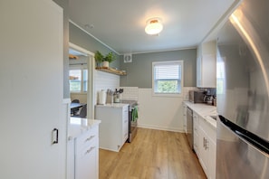 A kitchen with white cabinets, a stainless steel refrigerator, a wooden countertop, and a potted plant on the wall. - Walk to Dtwn Sandpoint! Family Gem w/ Patio & Yard (Sandpoint)