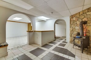 Un pasillo con piso de baldosas, paredes blancas y detalles de piedra.