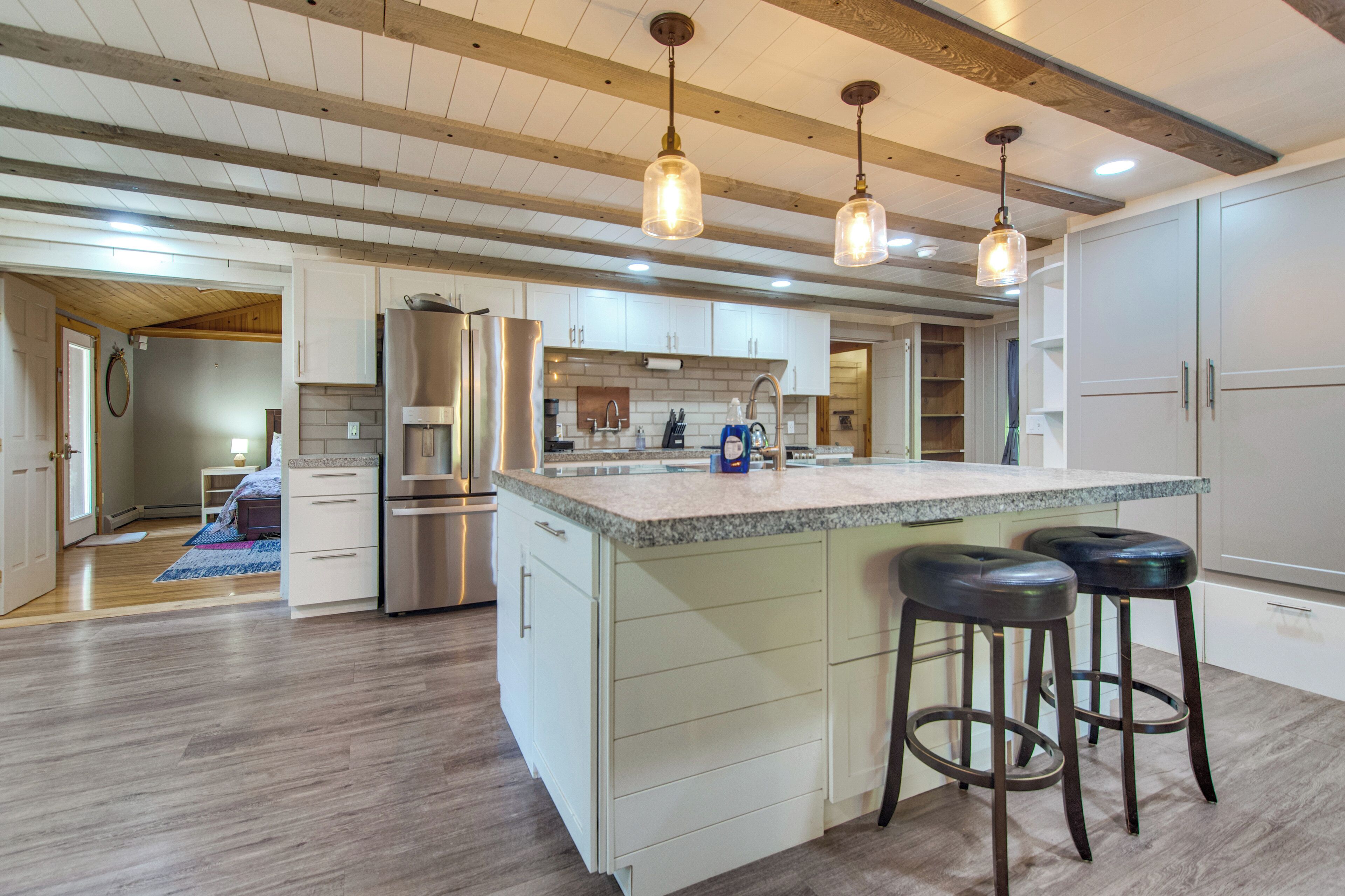 A spacious kitchen with a large island, stainless steel appliances, and pendant lighting.