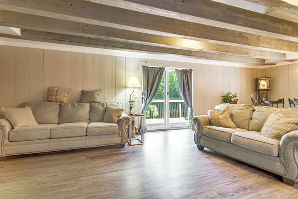 Ein Wohnzimmer mit zwei Sofas, einer Lampe und einer Uhr.