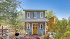 A two-story house with a front porch, a wooden fence, and a barbecue grill. - Brand New Casita by Superstition Mtns: Patio (Apache Junction)