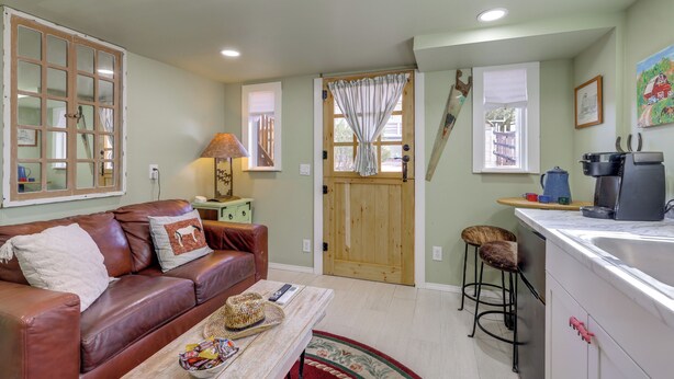 A cozy living room with a leather couch, a coffee machine, and a kitchen area with a sink and bar stools. - Brand New Casita by Superstition Mtns: Patio (Apache Junction)