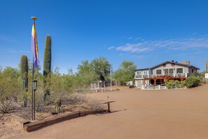A desert landscape with a building that has a porch and a fenced area. - Brand New Casita by Superstition Mtns: Patio (Apache Junction)