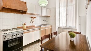 A kitchen with a stove, cabinets, and a dining table with chairs. - [VillinoAuroraVI] Near the station 5TERRE/Garden (La Spezia)