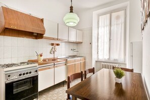 A kitchen with a stove, cabinets, and a dining table with chairs. - [VillinoAuroraVI] Near the station 5TERRE/Garden (La Spezia)