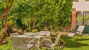 An outdoor dining area with a table set for four, surrounded by chairs with cushions. - [VillinoAuroraVI] Near the station 5TERRE/Garden (La Spezia)