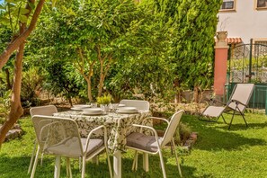 An outdoor dining area with a table set for four, surrounded by chairs with cushions. - [VillinoAuroraVI] Near the station 5TERRE/Garden (La Spezia)