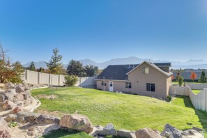 A residential house with a sloped roof, a front yard with a pathway, and a view of mountains in the background. - Patio & Mtn Views! Group Getaway in South Jordan (South Jordan)