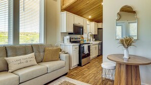 A modern kitchen with white cabinetry, a built-in oven, and a microwave.