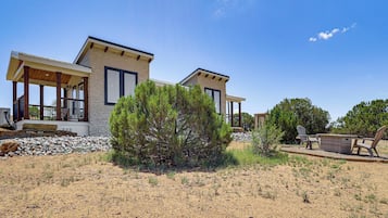 A two-story house with a covered porch and a small garden area.