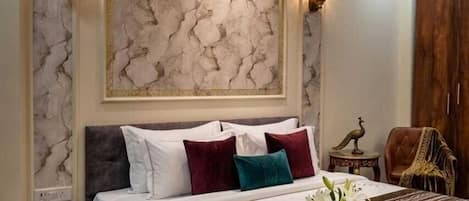 A bedroom with a large bed, a nightstand, a decorative wall piece, and a wooden wardrobe.