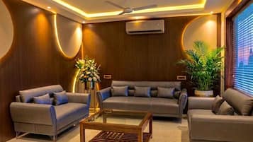 A modern living room with a sofa set, a coffee table, and a ceiling fan.