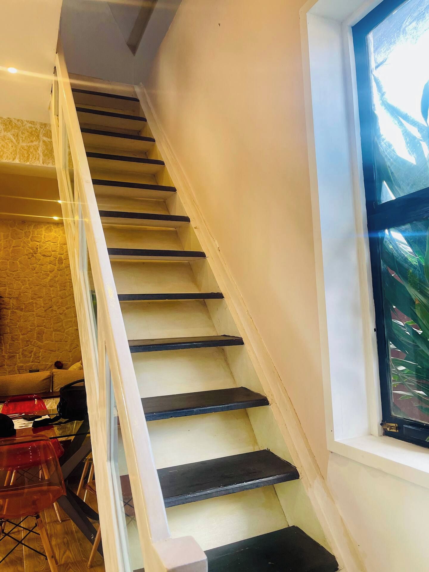 Eine Treppe mit Glastrennwand, die zu einer Zwischenebene führt.