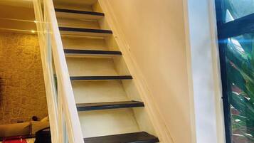 Eine Treppe mit Glastrennwand, die zu einer Zwischenebene führt.