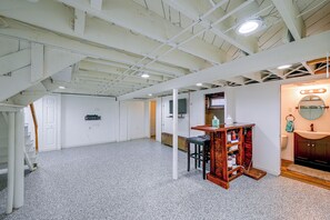 A room with a high ceiling, exposed beams, a white door, a small table with a mirror, and a radiator. - 1 Mi to Trolley Square! Family Home w/ Bar & Yard (Wilmington)