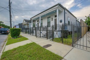 A two-story residential house with a covered porch, a gated driveway, and a well-maintained lawn. - Stylish Unit 3 Mi to French Quarter & Audubon Park (New Orleans)