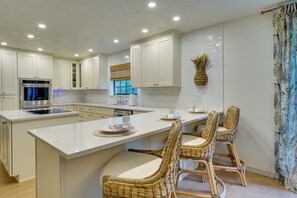 A modern kitchen with white cabinetry, a built-in oven, and a large island with bar stools. - 2 Mi to Silver Springs State Pk! Family Hideaway (Silver Springs)