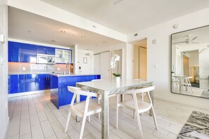 Eine moderne Küche mit blauen Schränken, einem weißen Esstisch und Stühlen.