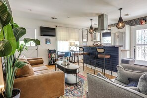 A modern living room with a sofa, a coffee table, and a dining area with chairs. - Eclectic Duplex in the Heart of High Point Terrace (Memphis)