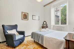 A bedroom with a bed, a chair, a radiator, and a window with a view. - [VillinoAuroraM] 5TERRE/Near the station (La Spezia)