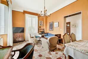 A living room with a television, a fireplace, and a dining area with a table and chairs. - [VillinoAuroraM] 5TERRE/Near the station (La Spezia)