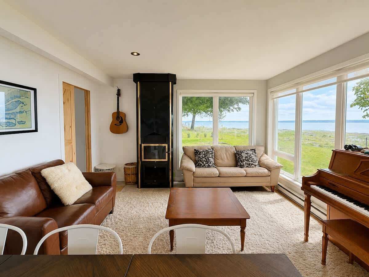 A living room with a piano, a sofa, a coffee table, and a fireplace.