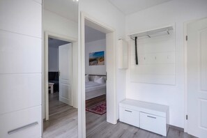 Ein modernes Schlafzimmer mit Bett, Nachttisch, Kleiderschrank und einem Badezimmer mit Dusche.