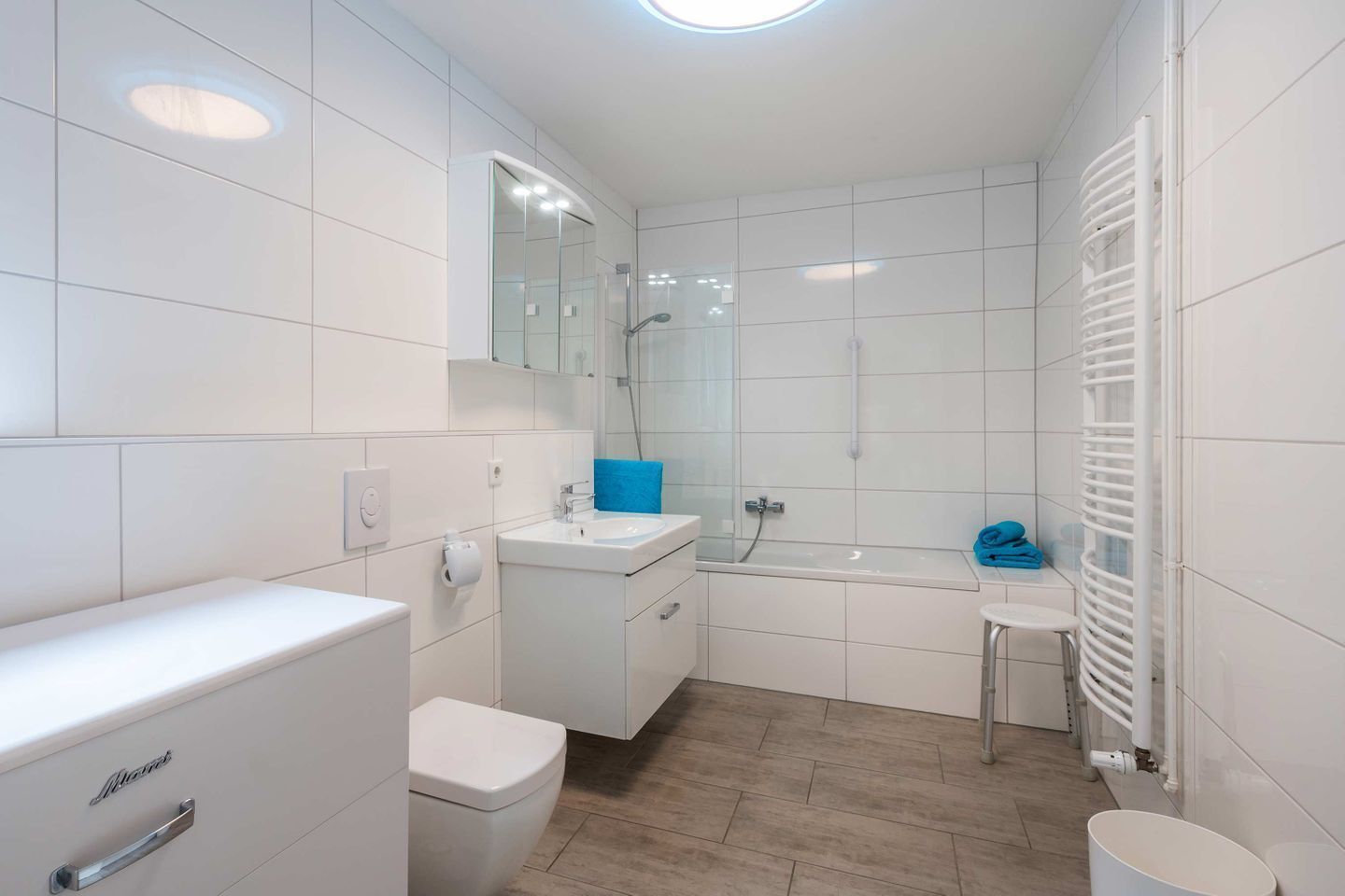 A modern bathroom with a toilet, sink, and bathtub.