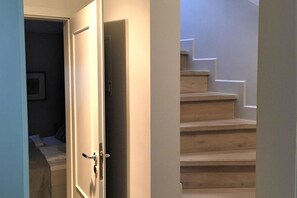 Un escalier menant à un deuxième étage, avec une porte sur le côté gauche.