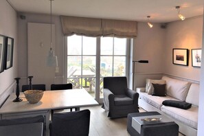 Ein modernes Wohnzimmer mit Essbereich, einer Couch und einem Tisch.