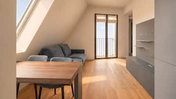 Un apartamento moderno con comedor, sofá y mueble para televisión.