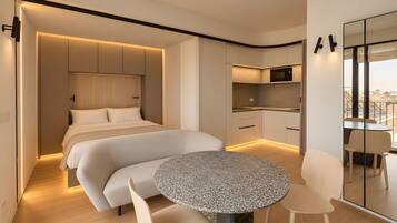 Une chambre d’hôtel moderne équipée d’un lit, d’une table à manger et d’un coin cuisine.