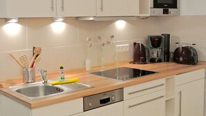 Een moderne keuken met roestvrijstalen apparatuur, een dubbele spoelbak en een koffiezetapparaat.