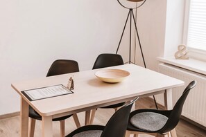 Une table à manger avec un saladier et un menu, entourée de chaises.