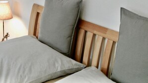 A bed with a wooden headboard and two pillows. - Alter Konsumverein, App No. 5 — An Oasis of Well-Being: Alter Konsumverein App No. 5 on Sylt (Sylt)