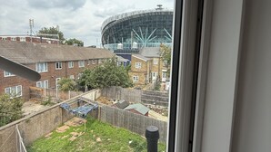 A view through a window of a residential area with a large stadium in the background. - 2 Min Walk to Tottenham Hotspur Stadium | Bright Studio (London)