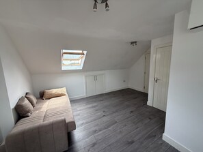 Ein Zimmer mit Hochbett, kleinem Fenster, Kleiderschrank und Tür.