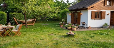 A house with a garden, a hammock, and outdoor furniture.