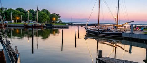 Una marina tranquila con barcos amarrados, un muelle de madera y cielo despejado.
