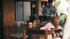 A wooden counter with jars, a kettle, and a potted plant. - Desa Cabins (Tabanan)