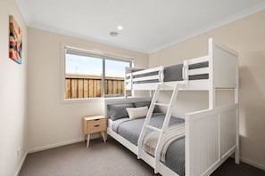 A bunk bed room with a window, a small bedside table, and a wall-mounted artwork. - The Grampian by Ready Set Stay (Cowes)